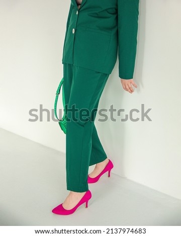 closeup female legs in pink heels and green classic suit on the white wall background. fashion concept, free space Royalty-Free Stock Photo #2137974683