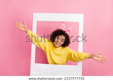 Photo of impressed sweet woman dressed kitted pullover easter headband open arms photo frame isolated pink color background