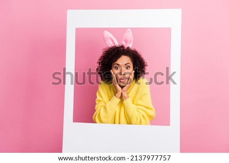 Photo of adorable impressed woman dressed kitted pullover easter headband arms cheeks photo frame isolated pink color background