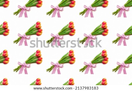 Beautiful yellow and red tulip flowers lie on a white background. Isolate, space for text, top view. Gift for a holiday to a woman and a girl. Pattern seamless
