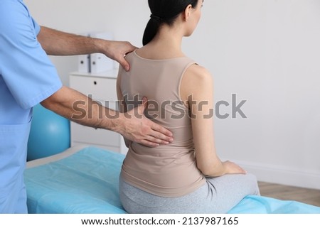 Orthopedist examining woman's back in clinic, closeup. Scoliosis treatment Royalty-Free Stock Photo #2137987165