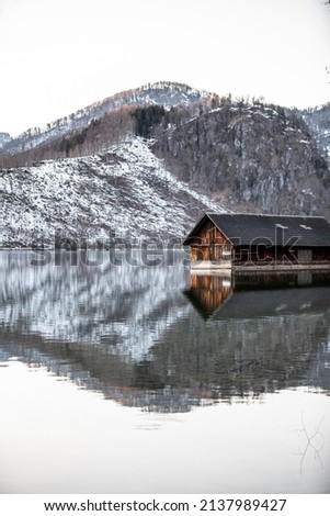 A wooden boathouse cabin in the mountain lake Almsee in Upper Austria Royalty-Free Stock Photo #2137989427