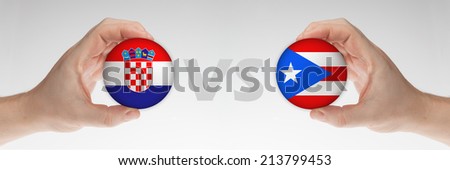 Man's hands holding styrofoam balls with Croatia and Puerto Rico flag against the white background.