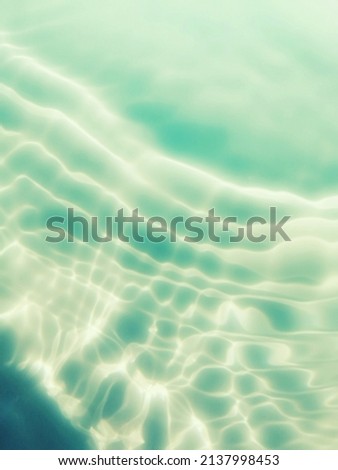 Closeup​ abstract​ of​ surface​ blue​ water​ for​ graphic​ design. Reflection​ of​ sunlight​ to​ surface​ blue​ water​ for​ background. Water​ splashed​ for​ abstract​ background. Blue​ water​ texture