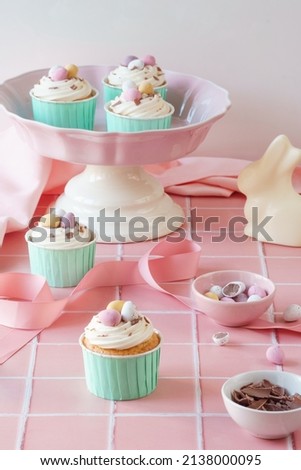 Easter egg food celebration image. Cupcakes, easter eggs, mini chocolate eggs and baking tools included in portrait frame. Pink and pastel colour spring colour theme.
