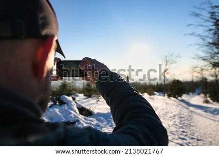 mountain hiker is taking photo of the sunset at mountain trail