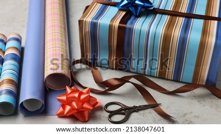 Beautifully wrapped gift box on grey stone table, closeup