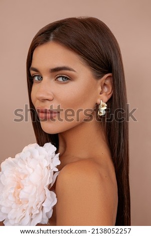 Pretty woman with bright makeup. Beautiful white girl with flowers. Stunning brunette girl with big bouquet of peonies. Closeup face of young beautiful woman with a healthy clean skin.