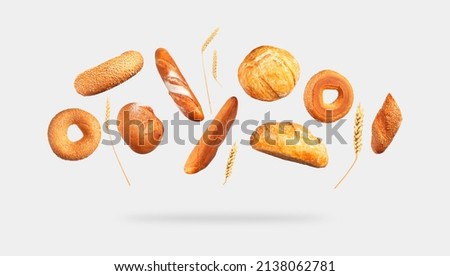 Various types of bread, ears of wheat flying on gray background. Classic wheat round bread, baguette, bun, sesame bagel. Organic Healthy Fresh isolated bread for bakery advertising. Food concept Royalty-Free Stock Photo #2138062781