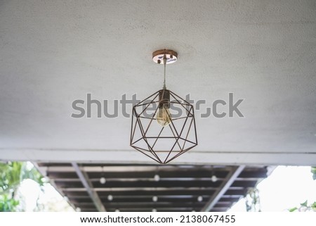hanging lamp from ceiling. Light bulb with geometric metal wires as chandelier with blurry background