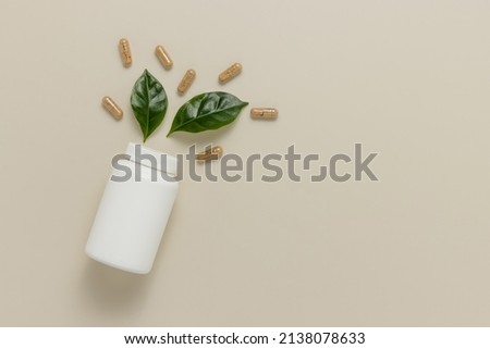 Top view mockup bottle for pills and vitamins with green leaves, natural organic bio supplement, copy space Royalty-Free Stock Photo #2138078633