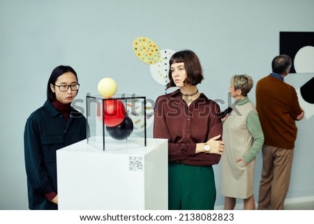 Group of modern senior and young people visiting exhibition in art gallery looking at various contemporary art objects and paintings Royalty-Free Stock Photo #2138082823