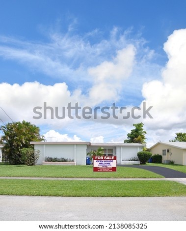 Home for Sale sign White Suburban Ranch Style Home in residential USA neighborhood
