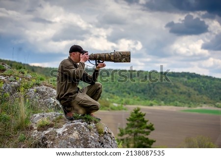Wildlife photographer in summer time working in the wild Royalty-Free Stock Photo #2138087535