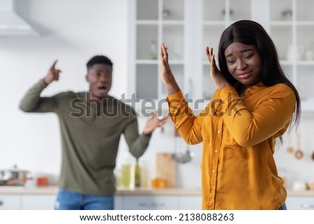 Psychological Abuse. Angry Young Black Man Shouting At His Scared Girlfriend In Kitchen, Upset African American Woman Suffering Domestic Violence From Her Husband, Selective Focus On Female Royalty-Free Stock Photo #2138088263