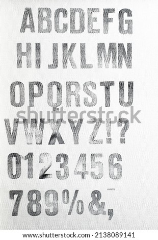 alphabet uppercase characters stamped with black ink on white canvas Royalty-Free Stock Photo #2138089141