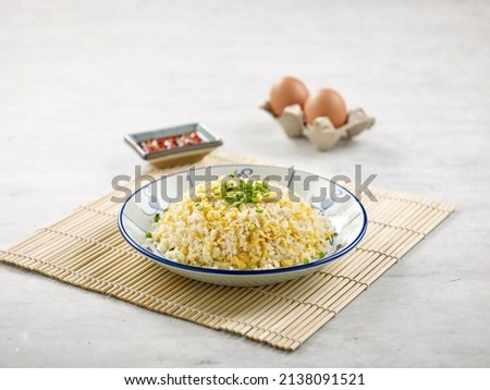 Fried Rice with Shredded Egg with sauce isolated on wooden mat side view on grey background a morning meal Royalty-Free Stock Photo #2138091521