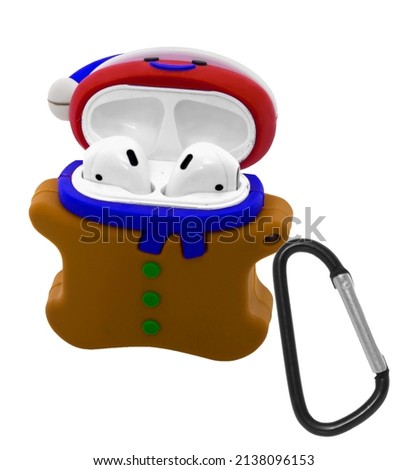 white wireless headphones in a silicone toy case snowman, with a carabiner on a white background in isolation