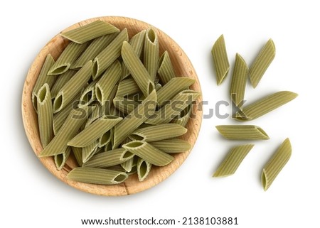 Green pea penne pasta in wooden bowl isolated on white background with clipping path. Organic food speciality. Gluten free. Top view. Flat lay