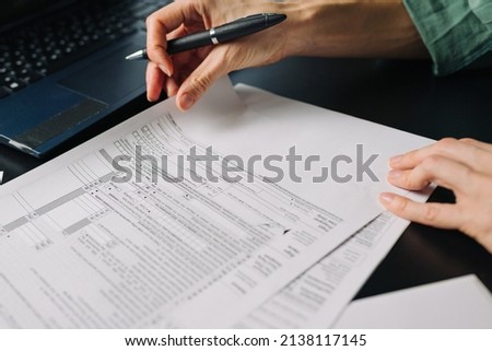 Woman filling US tax form 1040. tax form us business income office hand fill concept. Closeup Royalty-Free Stock Photo #2138117145
