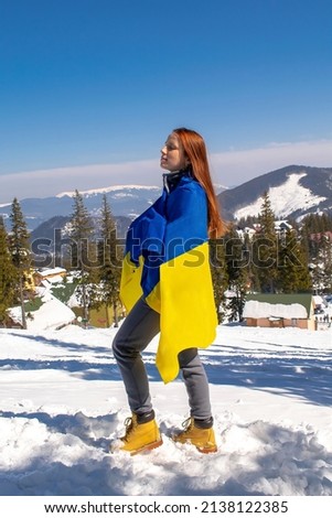 Woman holding,fluttering,waving ukrainian national blue yellow flag.war,conflict,military invasion beetwen Russia as terrorist aggressive country and Ukraine.Ukraines Independence,Constitution day.