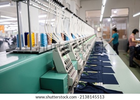 Modern and automatic high technology embroidery machine for textile or clothing apparel making manufacturing process in industrial. Close up Computerized embroidery machines. Digital textile industry. Royalty-Free Stock Photo #2138145513