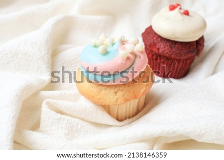 Vibrant cupcakes chocolate and red velvet with whipped vanilla cream on white background. Valentines day
