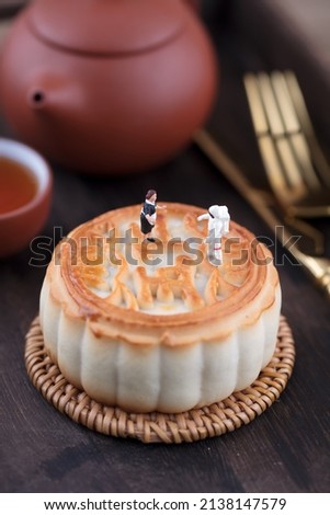 The astronaut and the chef are talking above the mooncake.The Chinese characters in the picture mean "five kinds of dried nuts"