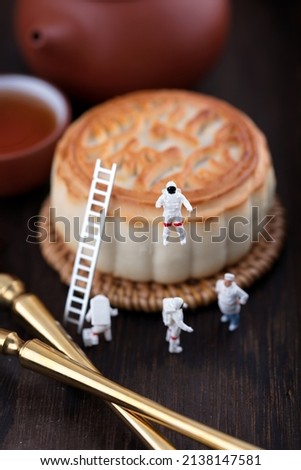 The astronaut is discussing the mooncake plan with the pastry chef.The Chinese characters in the picture mean "five kinds of dried nuts"