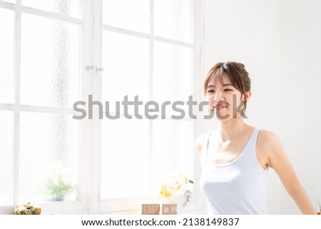 Beauty image of a woman stretching by a window