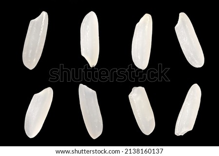 Top view, close-up macro shot. Uncooked long white brown rice grains, lying flat. Isolated on black background. Royalty-Free Stock Photo #2138160137