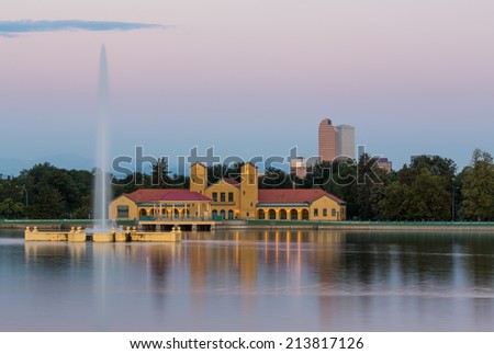Fountain and Boathouse at Ferril Lake with the city skyline of Denver Colorado in background just before sunrise