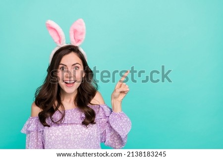 Portrait of attractive girly trendy cheerful girl wearing ears showing new copy space ad isolated over bright blue color background