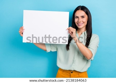 Photo of young pretty cheerful woman hold paper poster news advertise isolated over blue color background