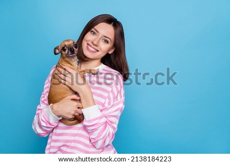 Photo of optimistic young brunette lady hug dog wear striped pullover isolated on blue background