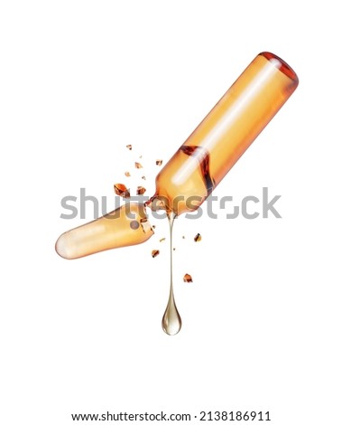 Stretched drop dripping from a crushed medical ampoule isolated on a white background