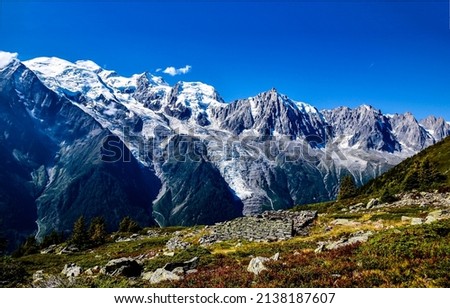 Mountain peaks and slopes on blue sky background. Mountain snowy peaks. Mountain snow on blue sky background. Mountain scene Royalty-Free Stock Photo #2138187607