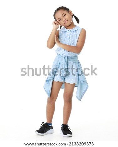 Portrait full body studio cutout shot of Asian young happy cheerful pigtail braid hairstyle elementary school girl in blue sleeveless dress standing posing smiling look at camera on white background.