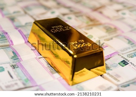 gold bar on russian money background with 1000 rubles banknotes. gold and foreign exchange reserves Royalty-Free Stock Photo #2138210231