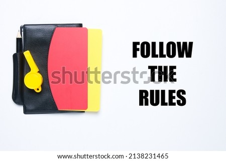 A picture of referee set book and follow the rules word. Obey and abide the law concept.