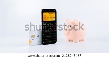 Online payment. Mobile phone with internet online bank app. Pig bank with credit card on white background. Online wallet save money