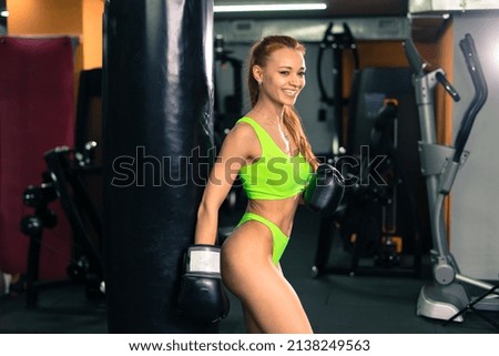 Beautiful muscular fit woman, she is exercising and building muscles