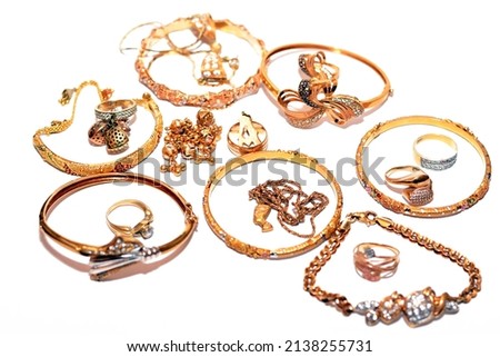 A set of gold accessories of rings, chains and bracelets isolated on white background, design golden jewellery, wristband, neck and ring accessories of precious metal jewelry, selective focus