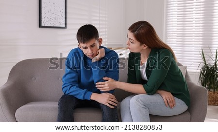 Mother consoling her depressed son at home. Teenager problems Royalty-Free Stock Photo #2138280853
