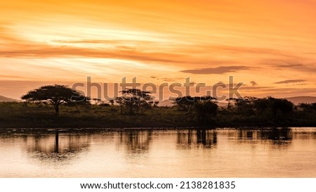 sunset by a water pool lake in the Savannah of South Africa Kwazulu Natal. beautiful sunset by the lake in South Africa during Safari