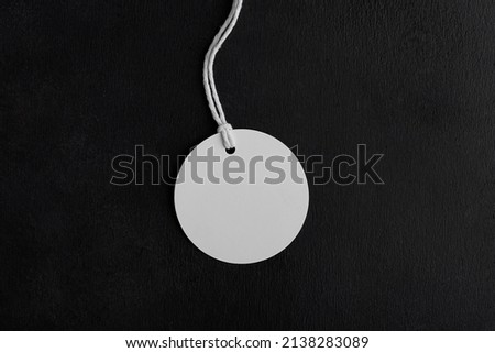 Round white tag label mockup with white cord, close up. Blank paper price tag isolated on black background with copy space, Sale and Black Friday concept Royalty-Free Stock Photo #2138283089