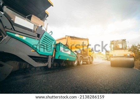 Vibratory asphalt rollers compactor compacting new asphalt pavement. Road service repairs the highway Royalty-Free Stock Photo #2138286159