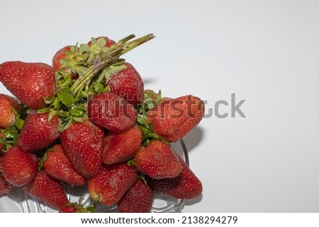 Heap of fresh strawberries in ceramic bowl on rustic white wooden background, Strawberries isolated on white background - Macro top down view with copy space