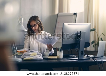 Beautiful young business woman sitting concentrated at her work in front of her office computer. Royalty-Free Stock Photo #2138297571