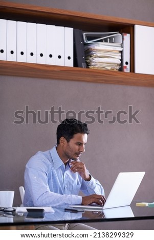Hes working hard to complete his tasks. Cropped shot of a handsome young businessman working at his desk.